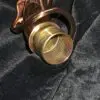 A brass pipe is sitting on a black cloth.
