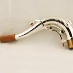 A silver saxophone with a wooden handle.