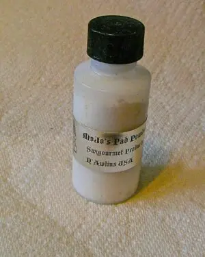 A bottle of white paint sitting on top of a table.