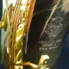 A close up of a saxophone with a hat on it.