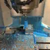 A machine is milling blue powder on the floor.