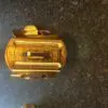A gold plated toaster sitting on top of a counter.