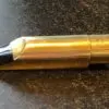 A gold pen with black tip on top of table.