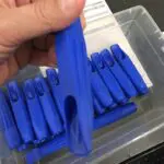 A person holding onto some blue plastic clips