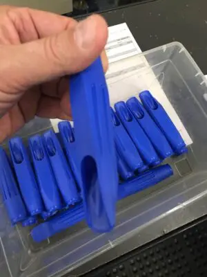 A person holding onto some blue plastic clips