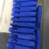 A bunch of blue plastic handles are sitting on the floor.