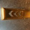 A gold metal object with arrows on it.