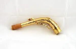 A gold colored trumpet with wooden handle.