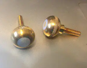 A pair of gold knobs with white numbers on them.