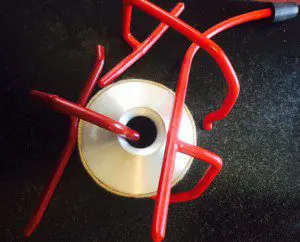 A red plastic pipe and a cd on top of it.