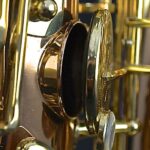 A close up of a gold saxophone.