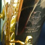 A close up of a saxophone with a hat on it.