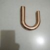 A copper pipe is bent to make the letter u.